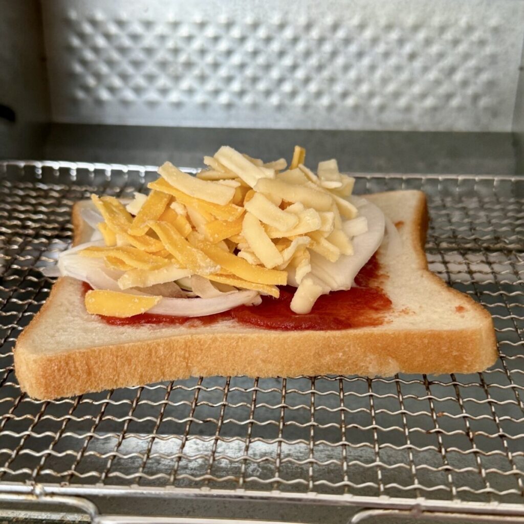 チーズトーストをオーブントースターに入れている画像