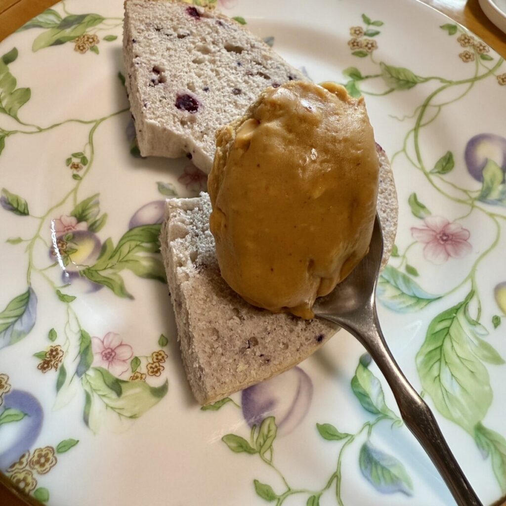 コストコのピーナッツバターをパンに塗っているところを撮った画像