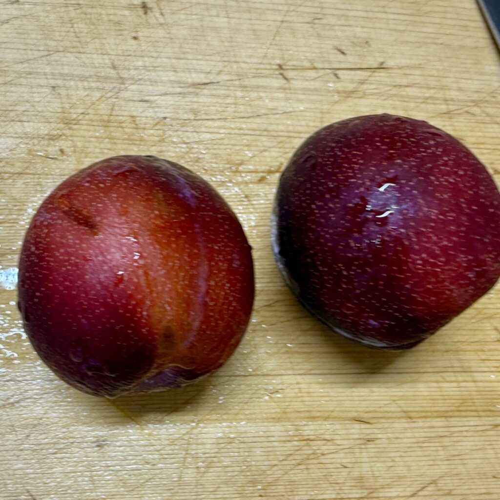 カリフォルニアプラムを2個まな板の上において撮った画像