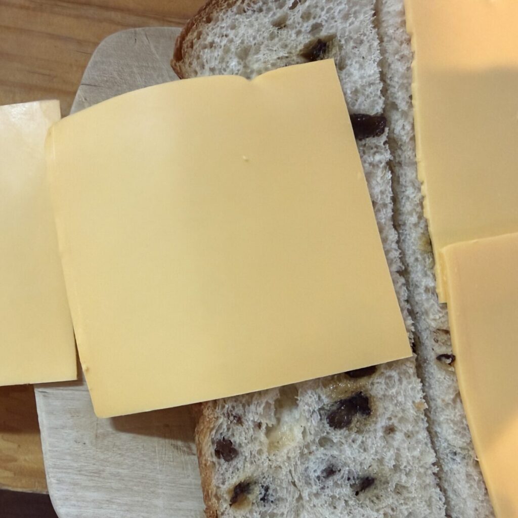 ROLF チェダーチーズ スライス 1300gをレーズン食パンにのせた画像