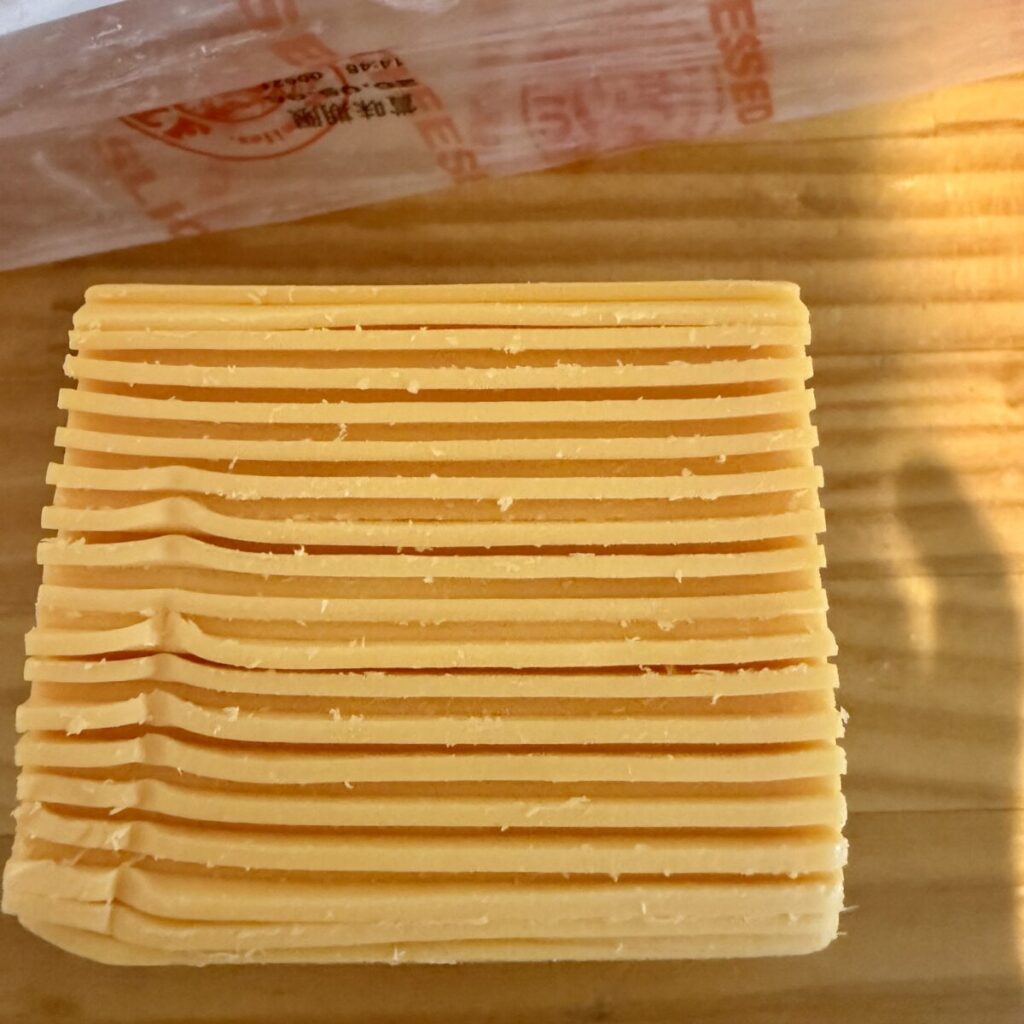 ROLF チェダーチーズ スライス 1300gが互い違いに並べられていることを示す画像