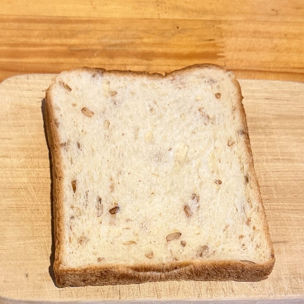 超熟ライ麦入り6枚スライスをカッティングボードの上に乗せたところを撮った画像