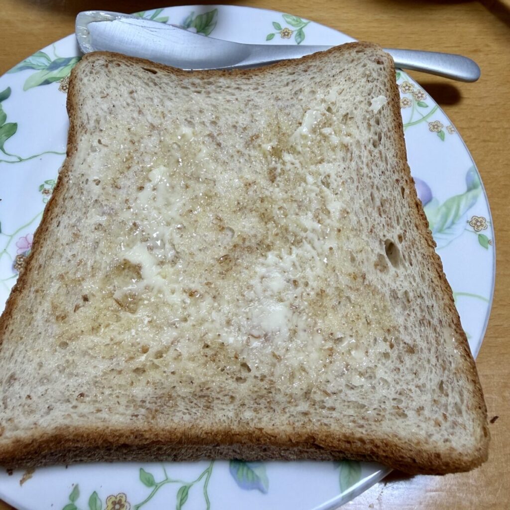麦のめぐみ全粒粉入り食パン6枚をトーストしてバターを塗って皿に盛り付けた画像