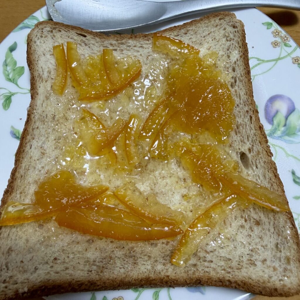 麦のめぐみ全粒粉入り食パン6枚にバターとマーマレードを塗って皿に盛り付けた画像
