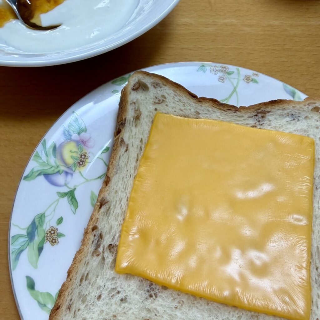 超熟ライ麦入り6枚スライスにスライスチーズをのせて焼いて皿に盛り付けた画像