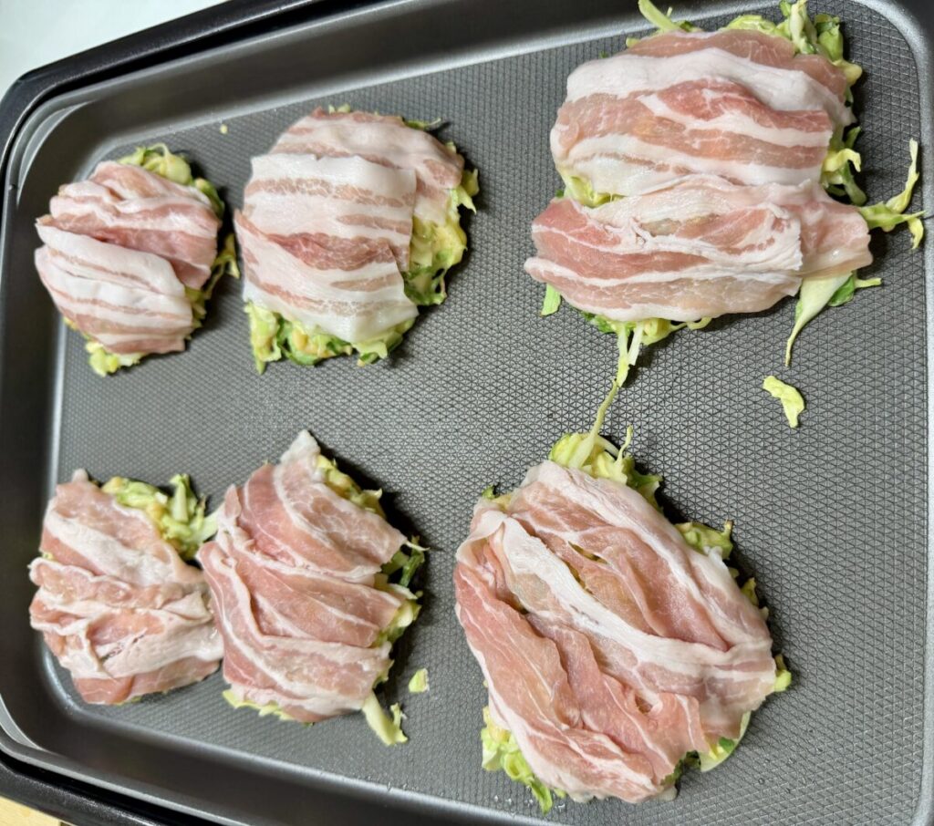 カナダ産三元豚バラしゃぶしゃぶを使ってお好み焼きを焼いている画像