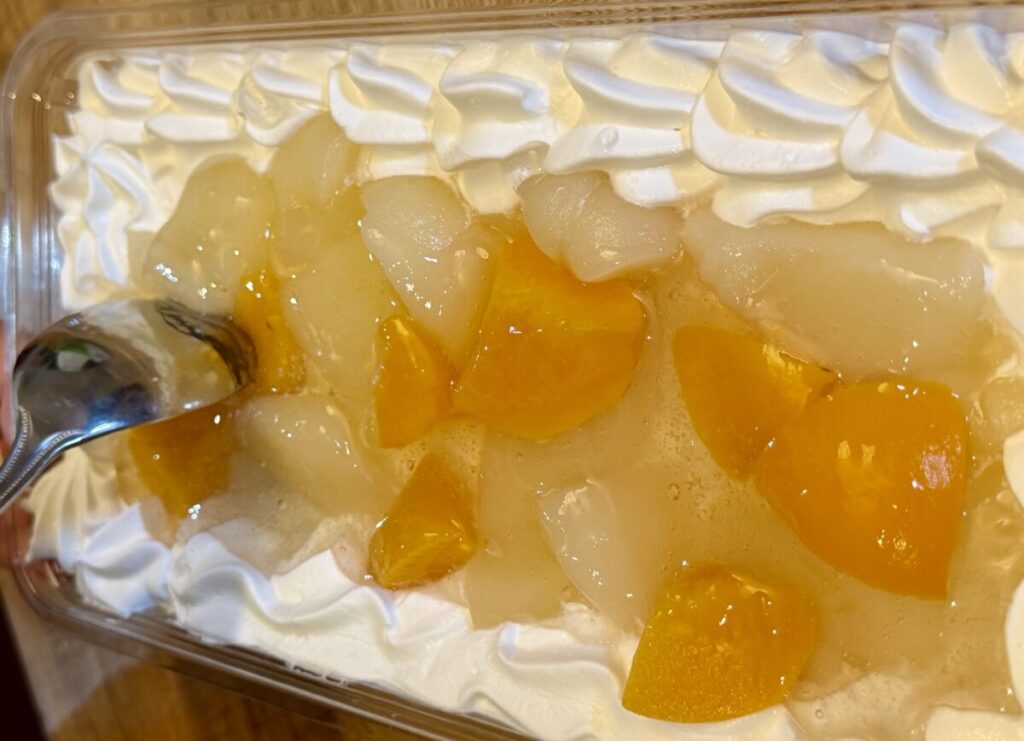 ピーチヨーグルトスクープケーキをスプーンで取り分けるところを撮った画像