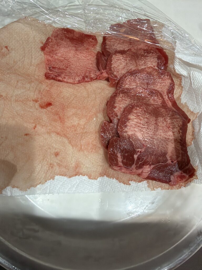 スライスした牛タンとキッチンペーパー